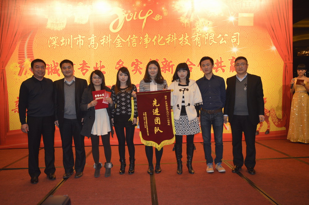 深圳市高科金信净化科技有限公司外贸商务中心在公司领导正确布署下,在外贸商务中心全体同仁的努力下,在2013年 度创造了3000多万的业绩,此举翻开了高科金信海外市场的新篇章。为表彰外贸商务中心的突出贡献,授予外贸商务中 心“先进团队”光荣称号,由周勤斌董事长颁发荣誉证书、文明勋总经理颁发锦旗,并给予外贸商务中心现金奖励。周 勤斌董事长、文明勋总经理与外贸商务中心同事合影留念;